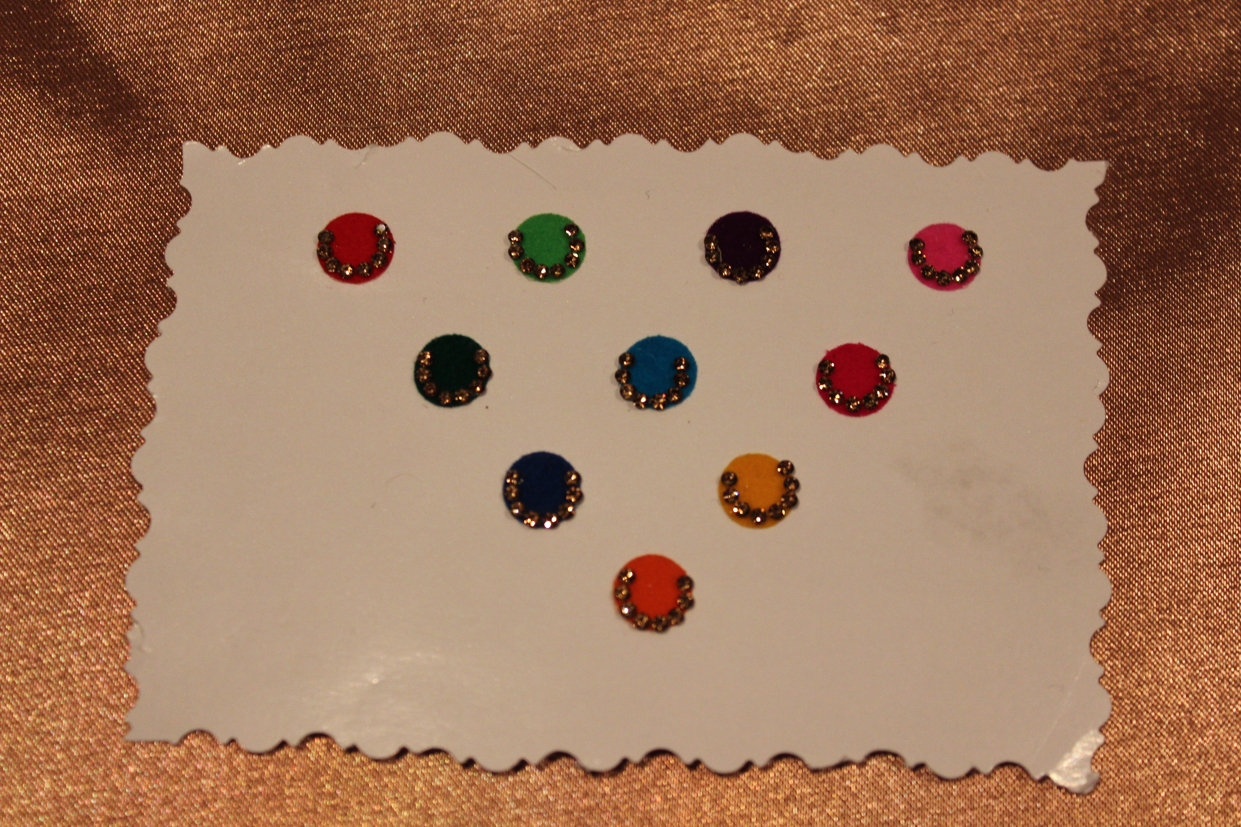 Bindis are coloured dots worn on the centre of a woman's forehead they come in various designs and shapes.   A card of bindis come in different colours and are reusable. To reuse the adhesive after it is worn off, we recommend the use of eyelash glue for application. 