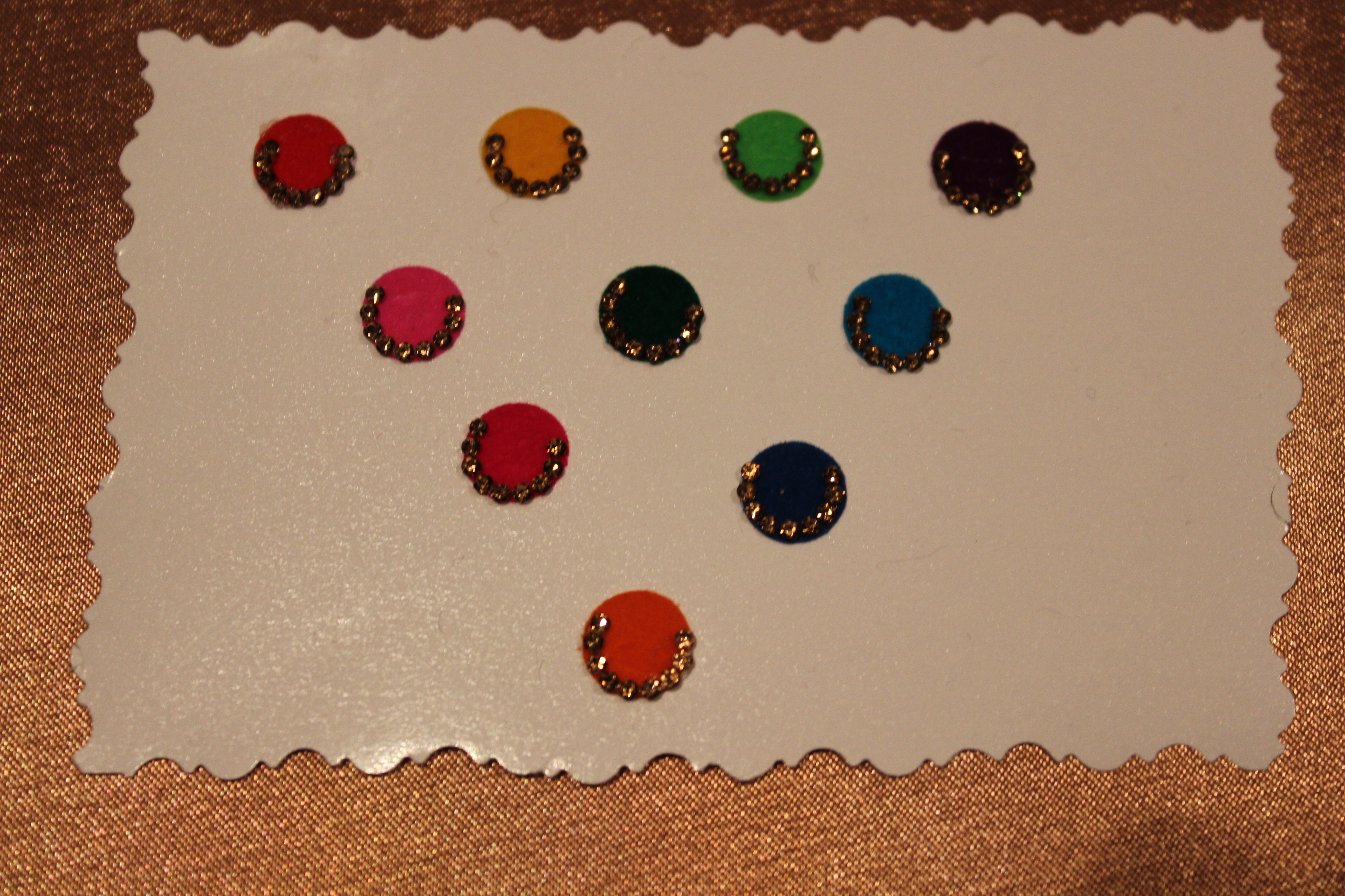 Bindis are coloured dots worn on the centre of a woman's forehead they come in various designs and shapes.   A card of bindis come in different colours and are reusable. To reuse the adhesive after it is worn off, we recommend the use of eyelash glue for application. 